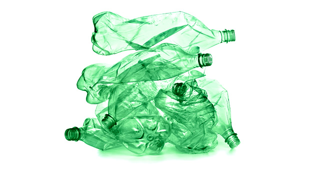 Small pile of crumpled green plastic bottles