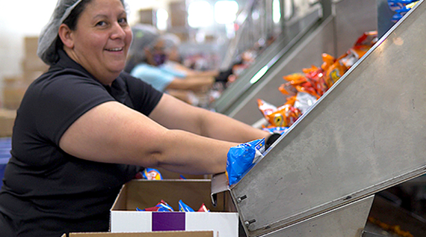 Happy woman on packaging assembly line